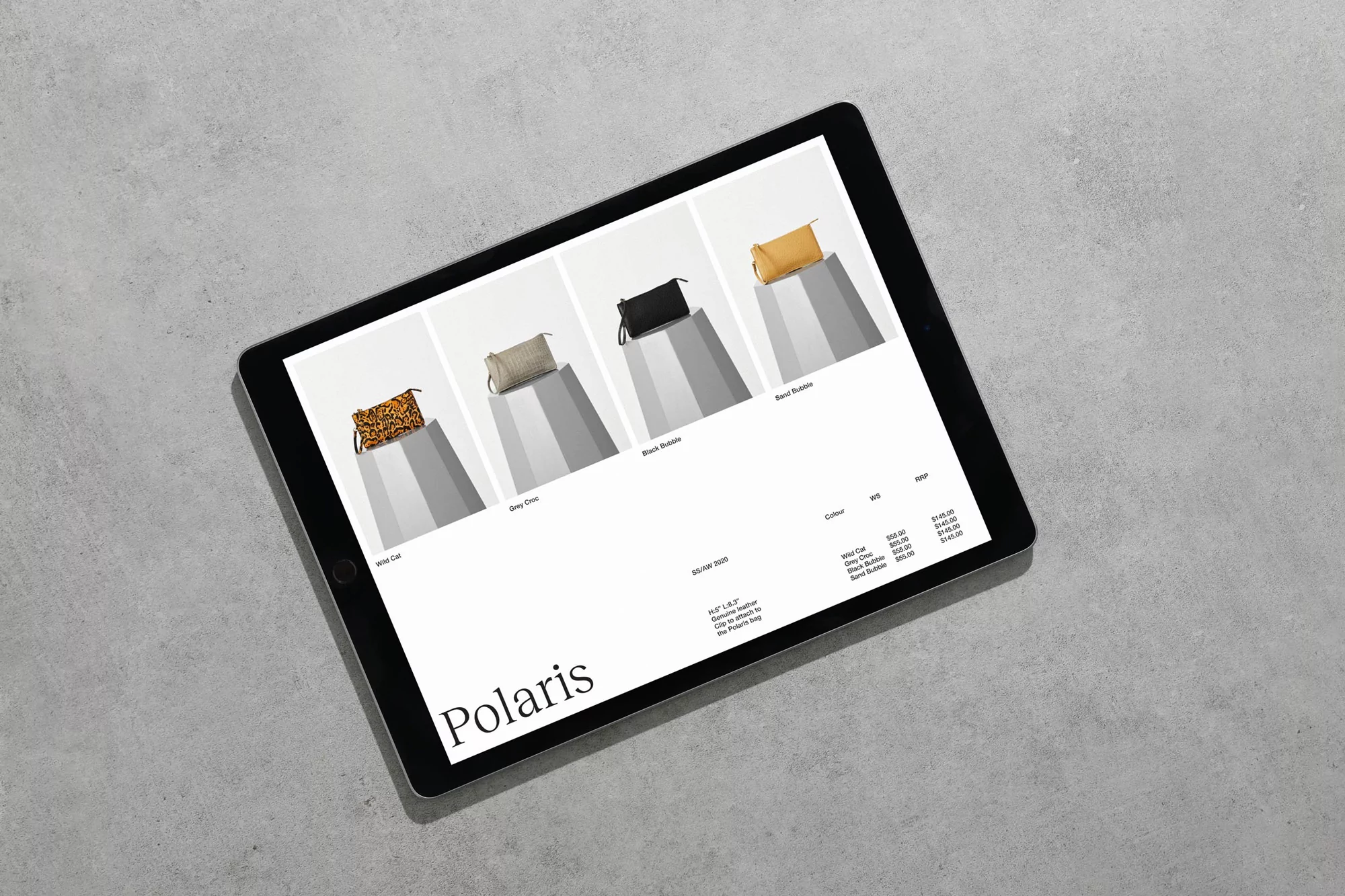 Tablet displaying a product catalog of designer handbags in various styles and colors against a neutral grey concrete background.