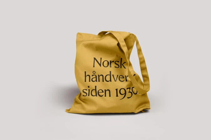 Yellow cotton tote bag with black printed text against a neutral background for product advertising or brand promotion.