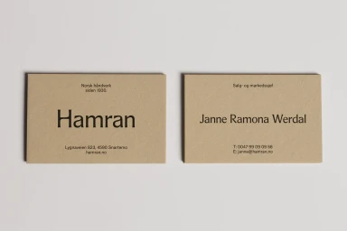 Two tan textured business cards with dark brown typography laid out side by side on a plain light surface