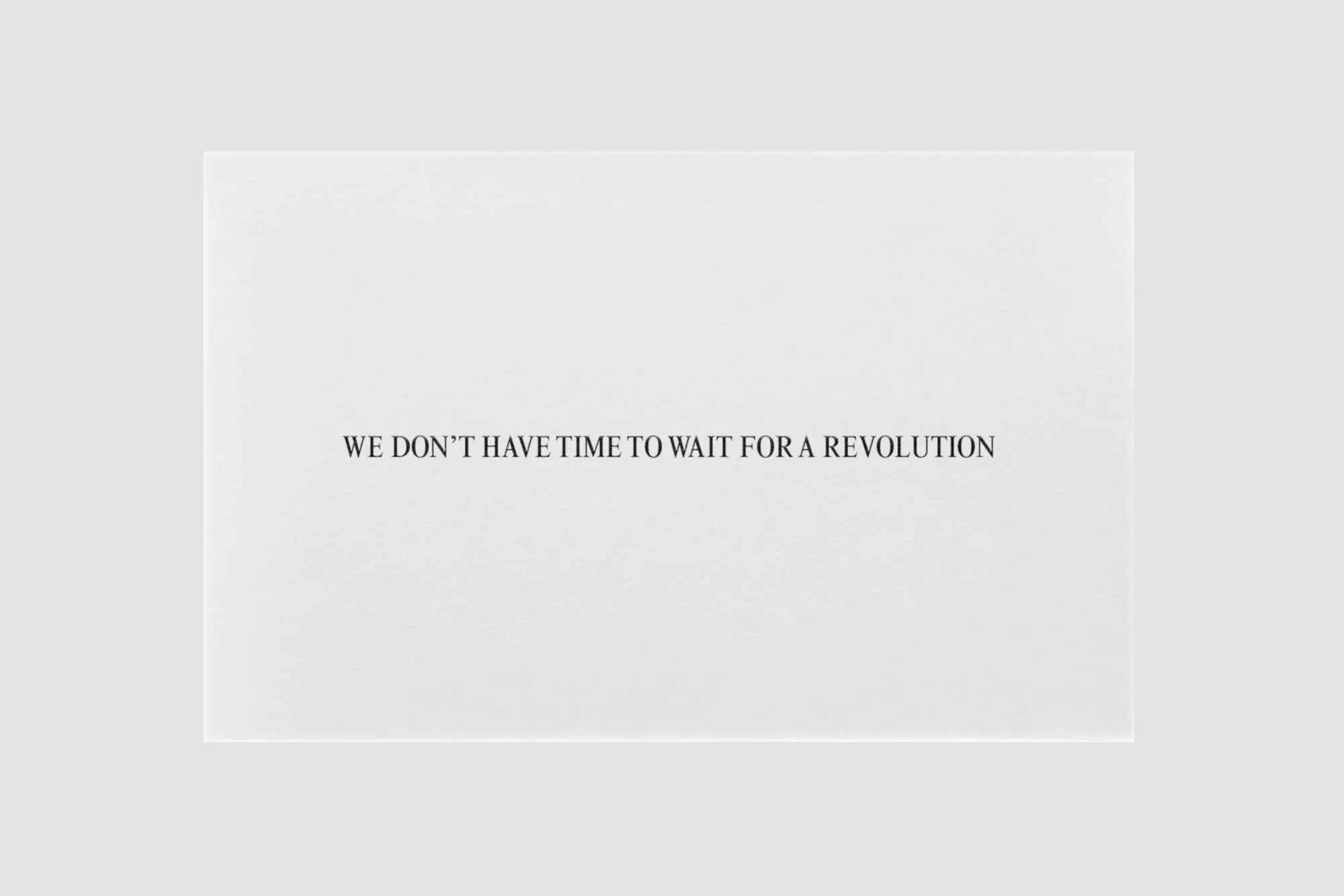 Black text on a white surface stating, 'WE DON'T HAVE TIME TO WAIT FOR A REVOLUTION,' emphasizing urgency and proactive change.