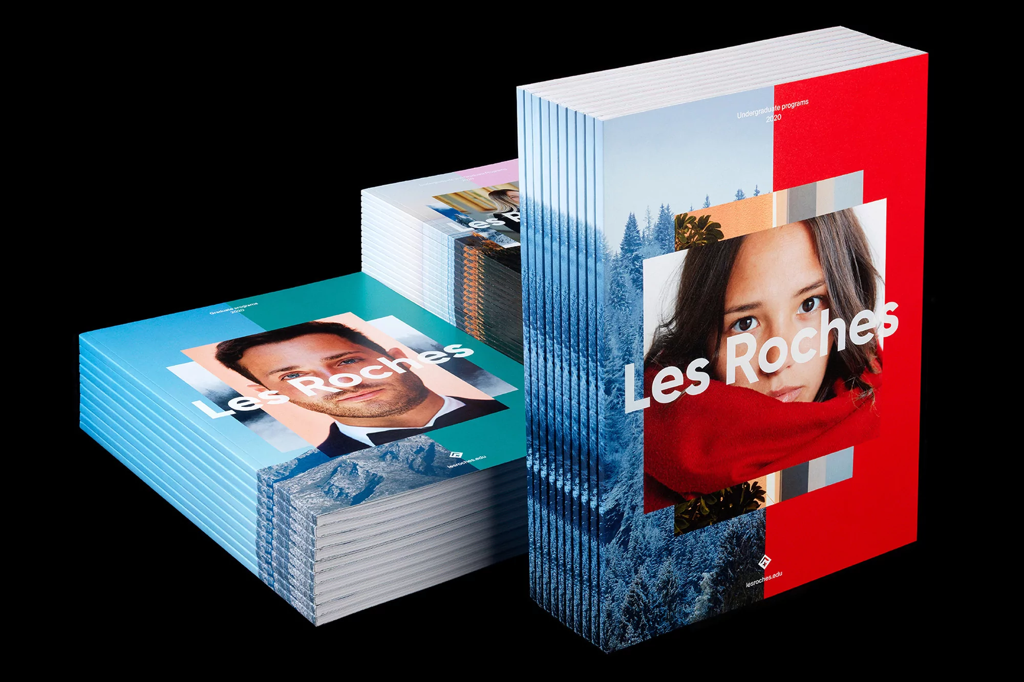 Stacks of 'Les Roches' brochures with model faces and mountain landscapes. Brochures are offset on black backdrop. 