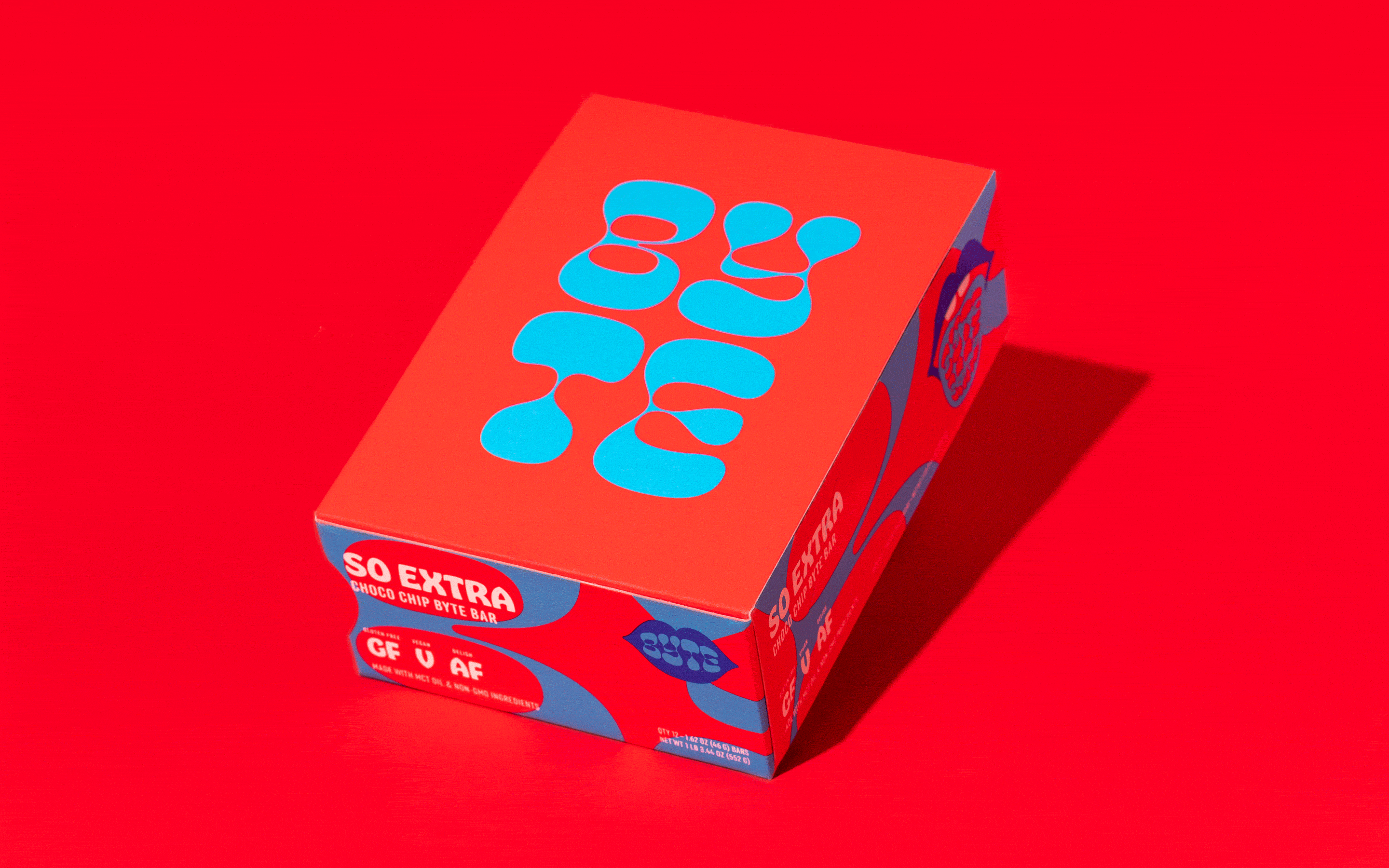 Box of So Extra Choco Chip Byte Bars against a vibrant red backdrop, featuring bold turquoise graphics and text on its packaging.