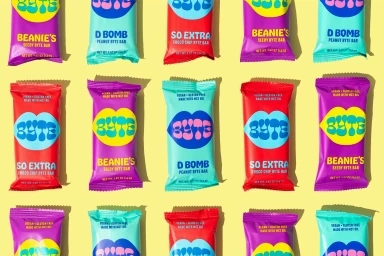 A flat lay of colorful Byte snack bar wrappers arranged in a neat grid on a yellow background
