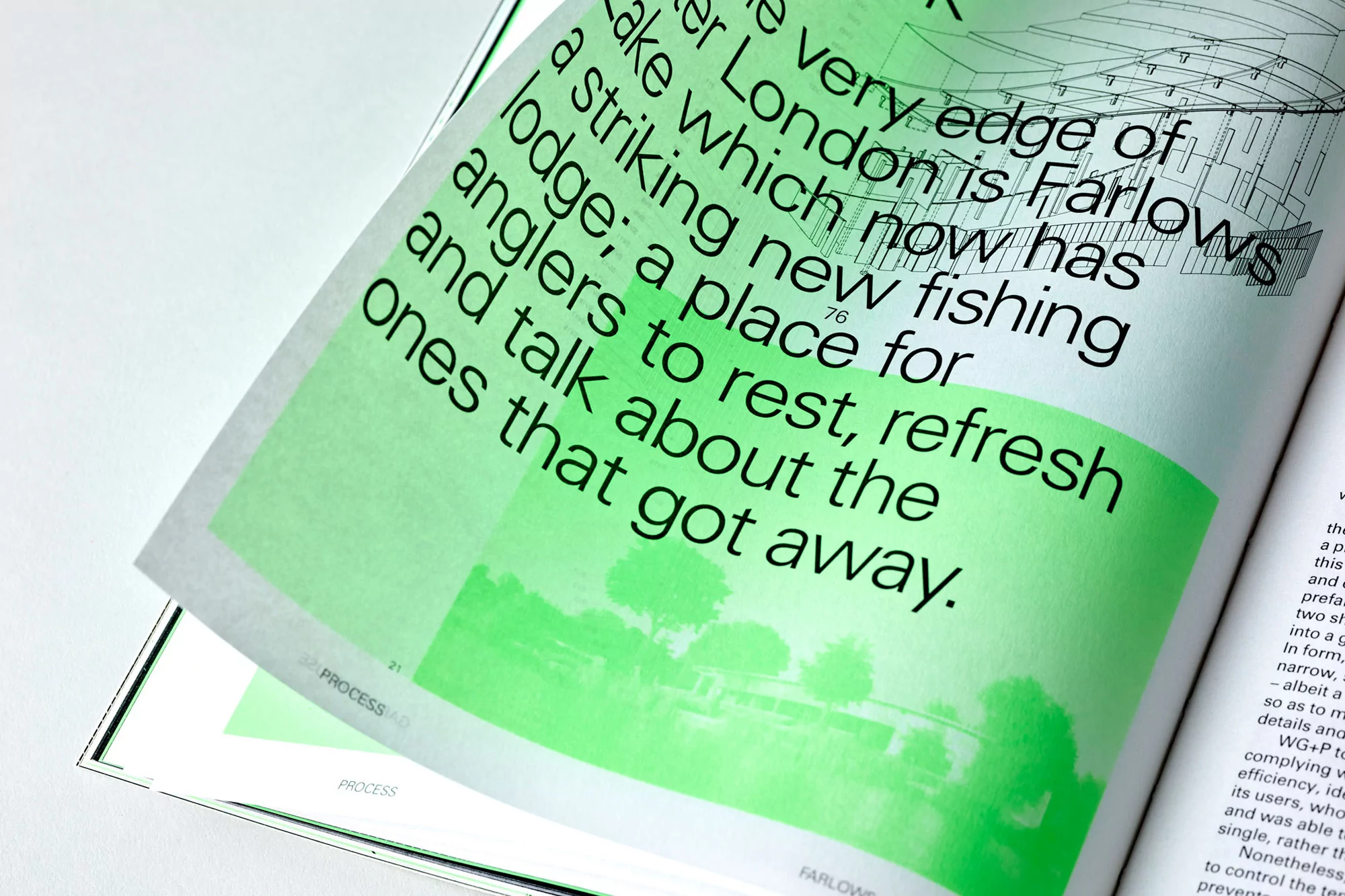Close-up of an open architecture magazine with green text overlaying a landscape illustration. Layout displays black text with a blueprint.