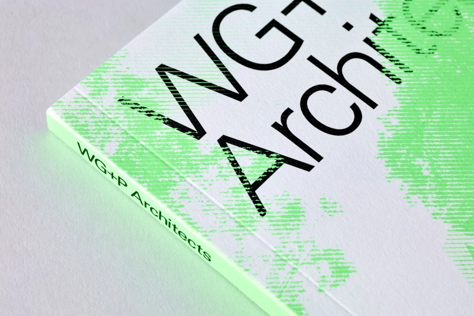 Close-up of a book cover with bold black typography 'WG Architects' on a white background with a light green patterned design.