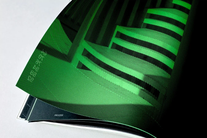 Abstract graphic art featuring diagonal stripes in shades of green and black, showcased within the pages of a printed magazine.