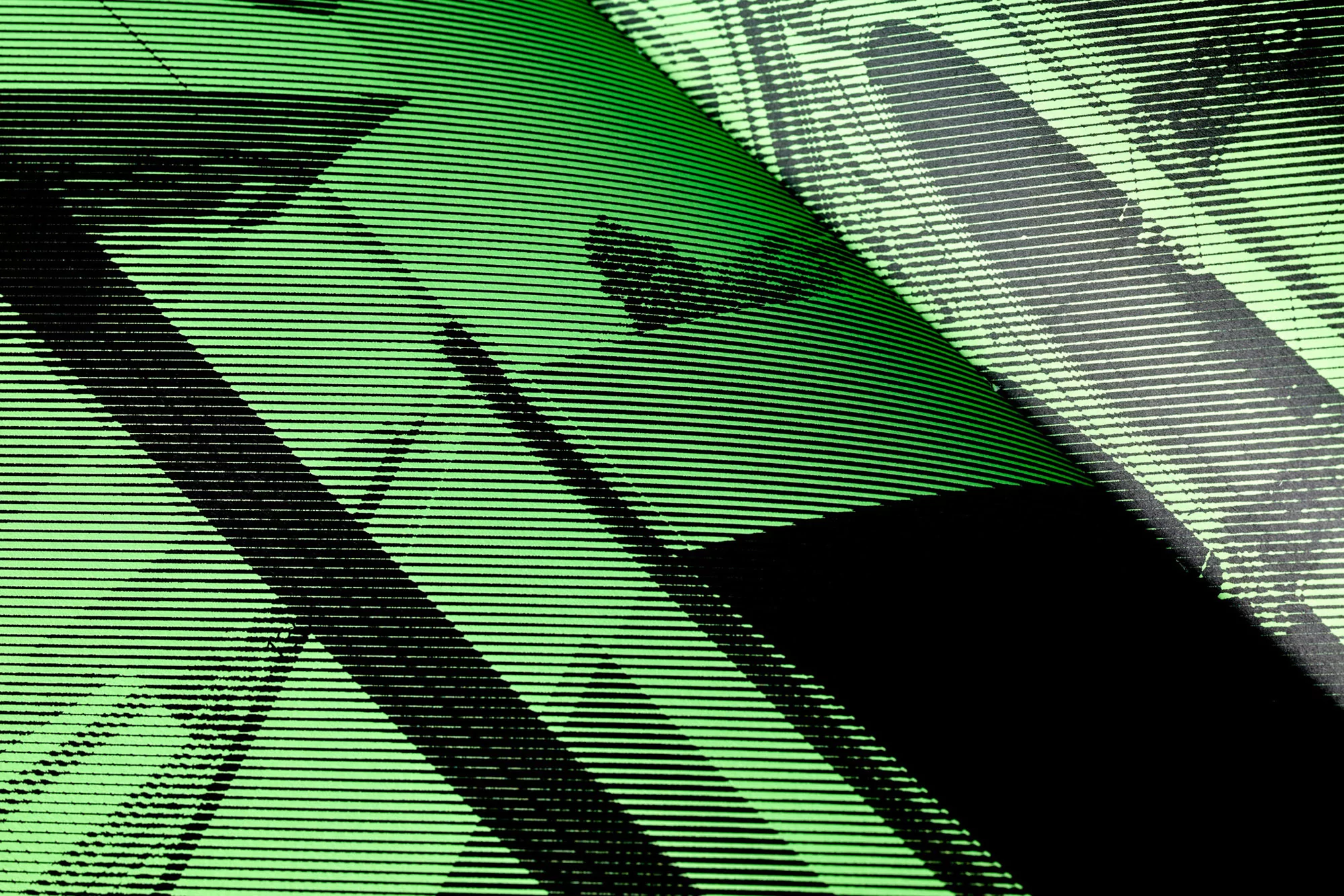 Abstract background featuring angled black shapes and lines on a vibrant green surface with linear texture and an overall modern graphic design.