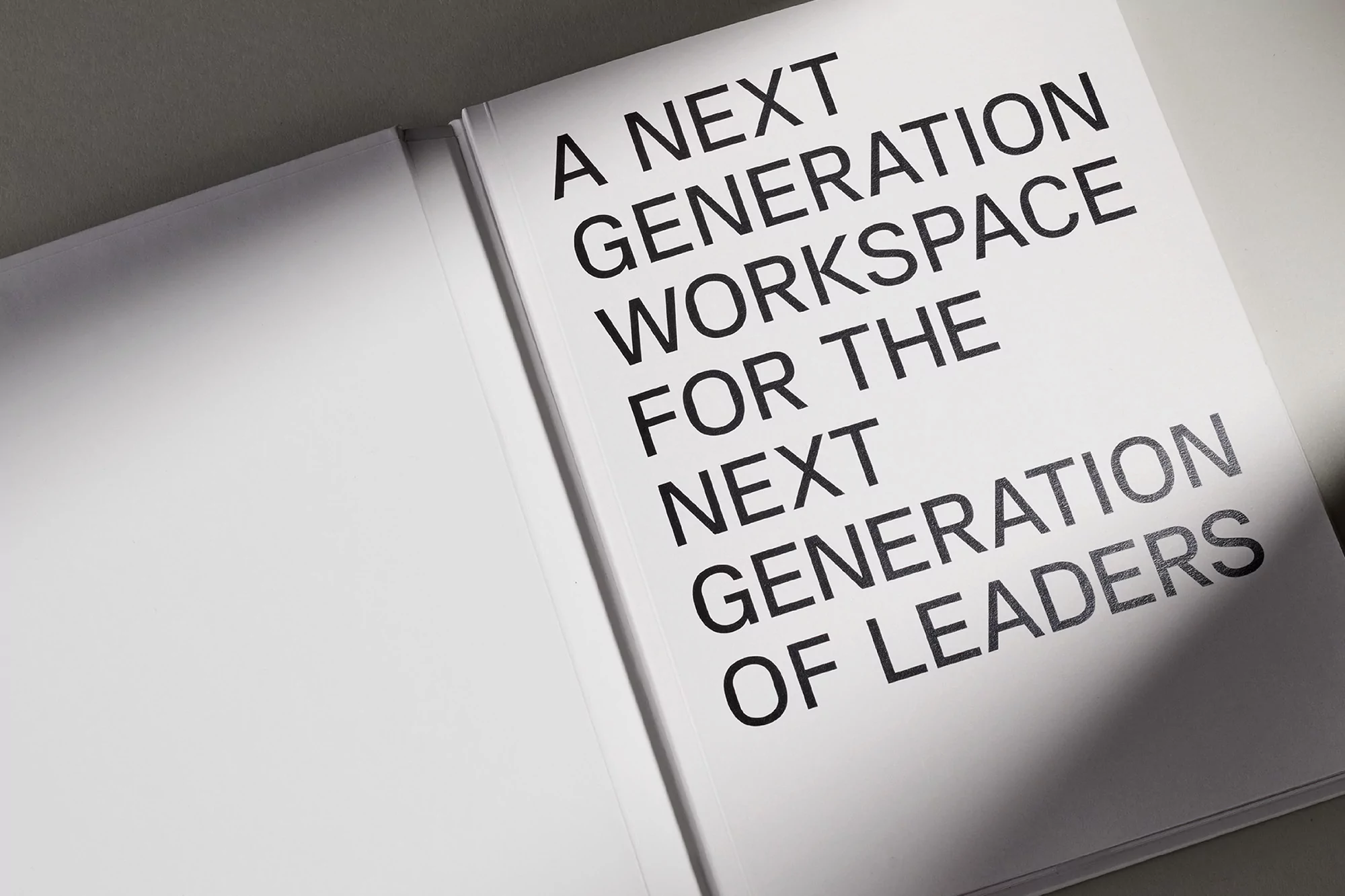 Opened book featuring the text 'A Next Generation Workspace For The Next Generation of Leaders' in black font on a white page.