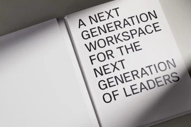 Open white book displaying bold uppercase sans serif typography on the right page under soft directional light