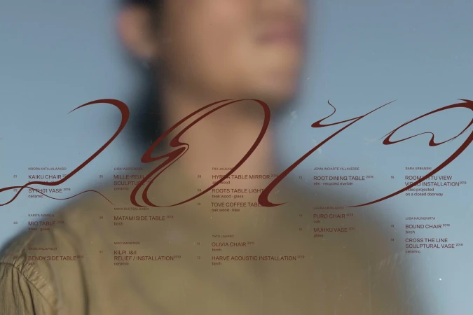Abstract design of the year 2019 with furniture and installation titles visible behind it, against a blurred background with a person.