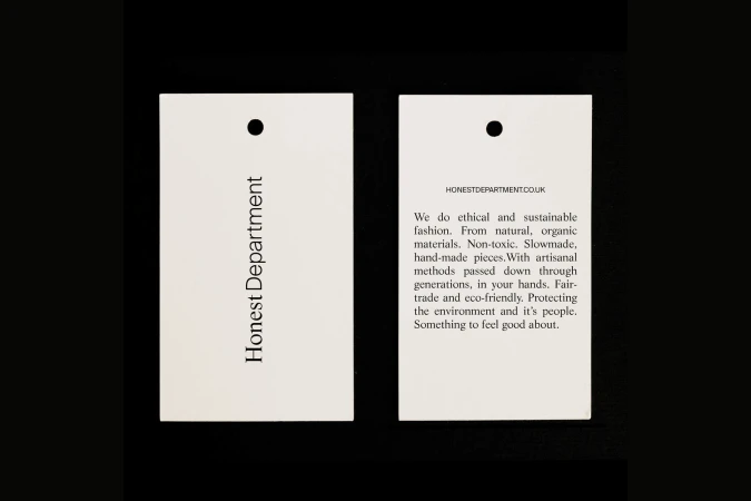 Two product hang tags on a black background. One reads 'Honest Department' while the other details the brand's ethical fashion.