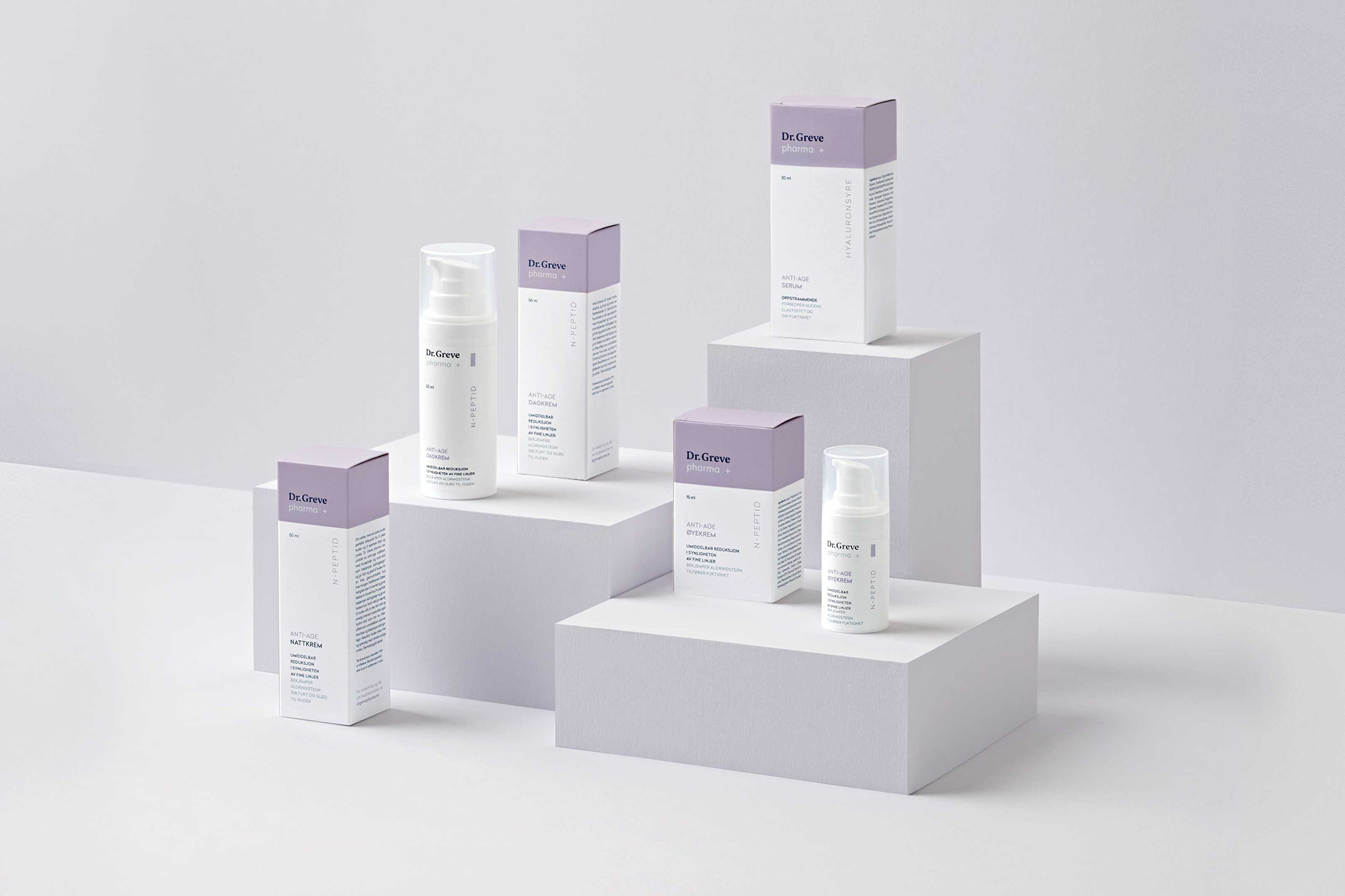 Cosmetic product line by De Grove featuring anti-age serum and hydration on a white platform with lavender and white packaging.