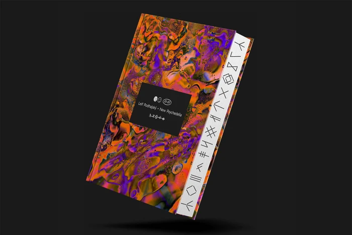 Hardcover book with vibrant abstract orange and purple patterned cover floating against a dark background
