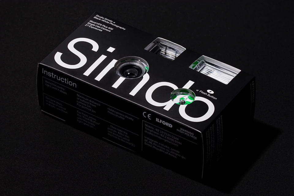 Black and white single use camera in its product packaging. Simdo branded disposable camera box on a dark grey background.