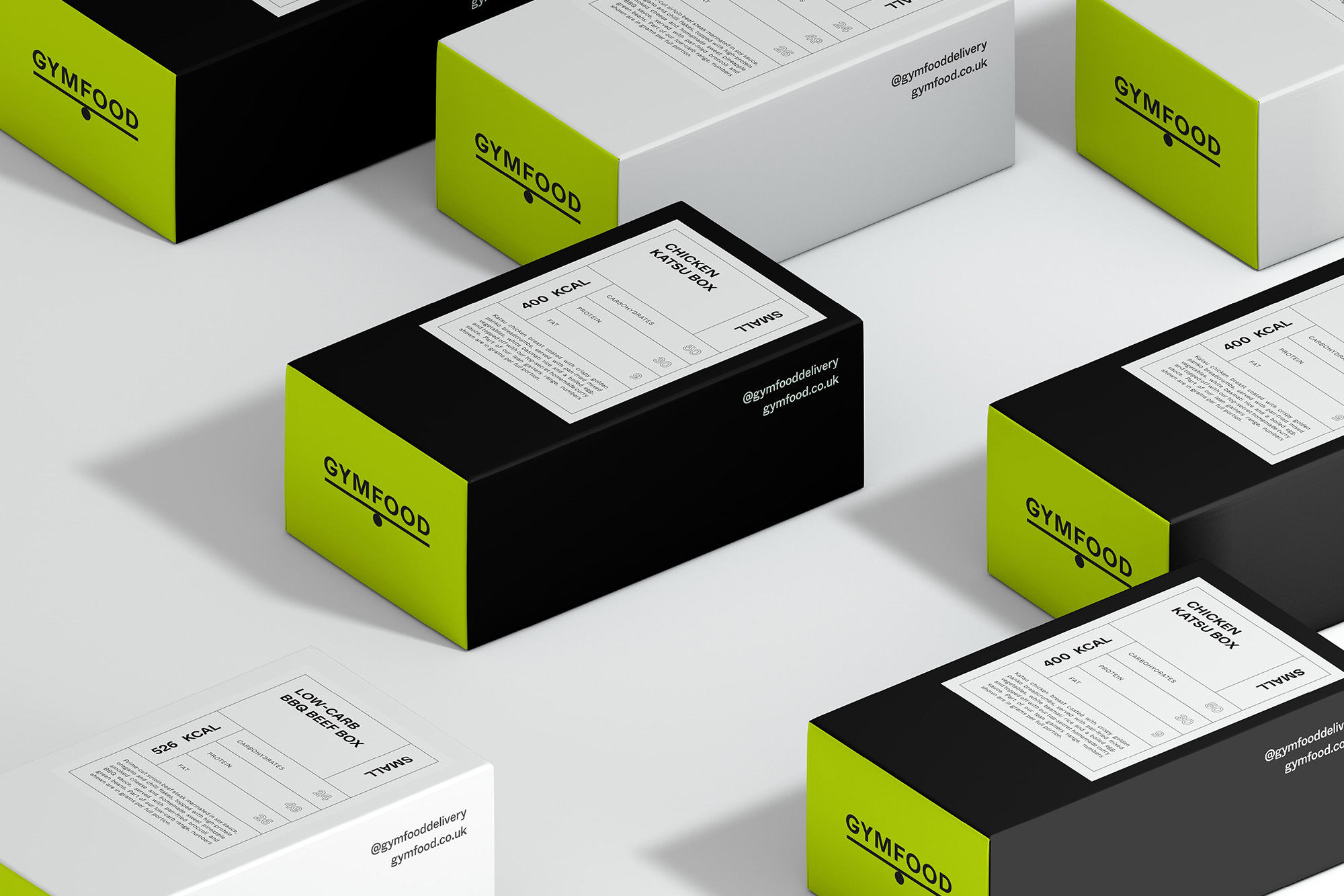 Several black and white Gymfood meal boxes with nutritional information are arranged on a clean, white surface, food and beverage.