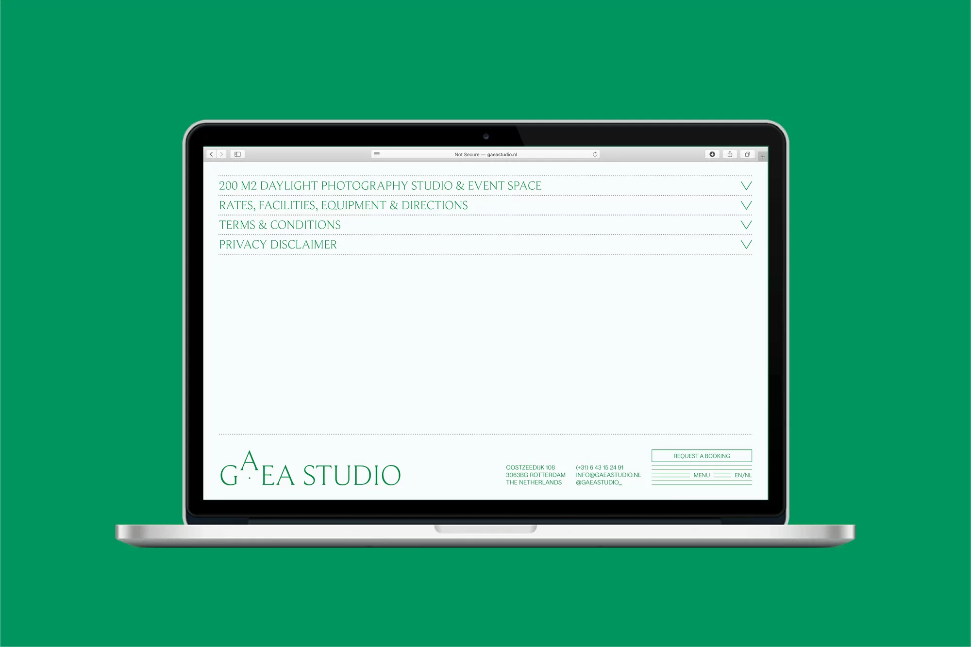 Laptop displaying website on green background. The site features text for a photography studio, including rates, terms, and location details.