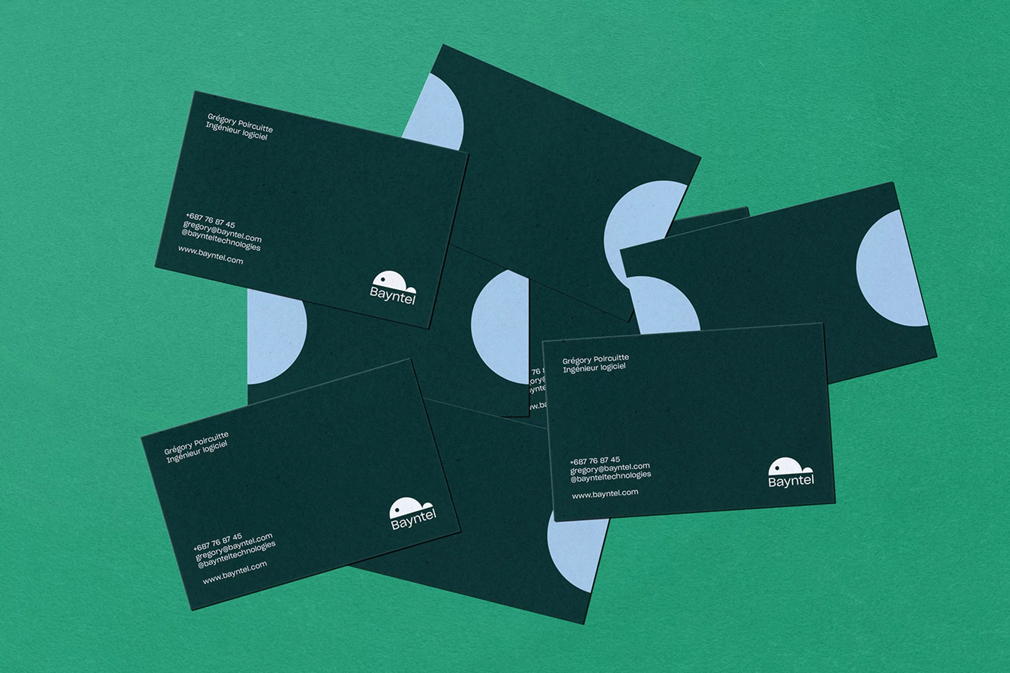 Pile of dark teal business cards on a green background, featuring the company logo, name, contact information, and geometric design.