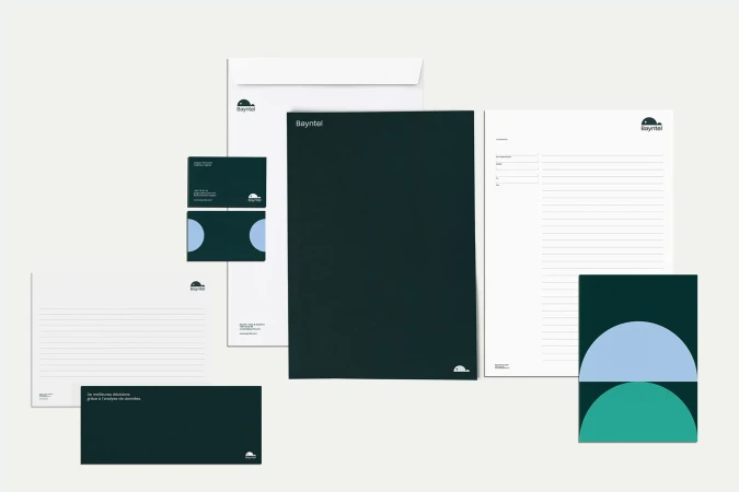 Corporate branding materials including letterhead, envelope, business cards, and presentation folders with a dark green and white theme.