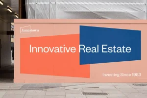 Branded construction hoarding with geometric shapes and text reading Innovative Real Estate by Bayntel