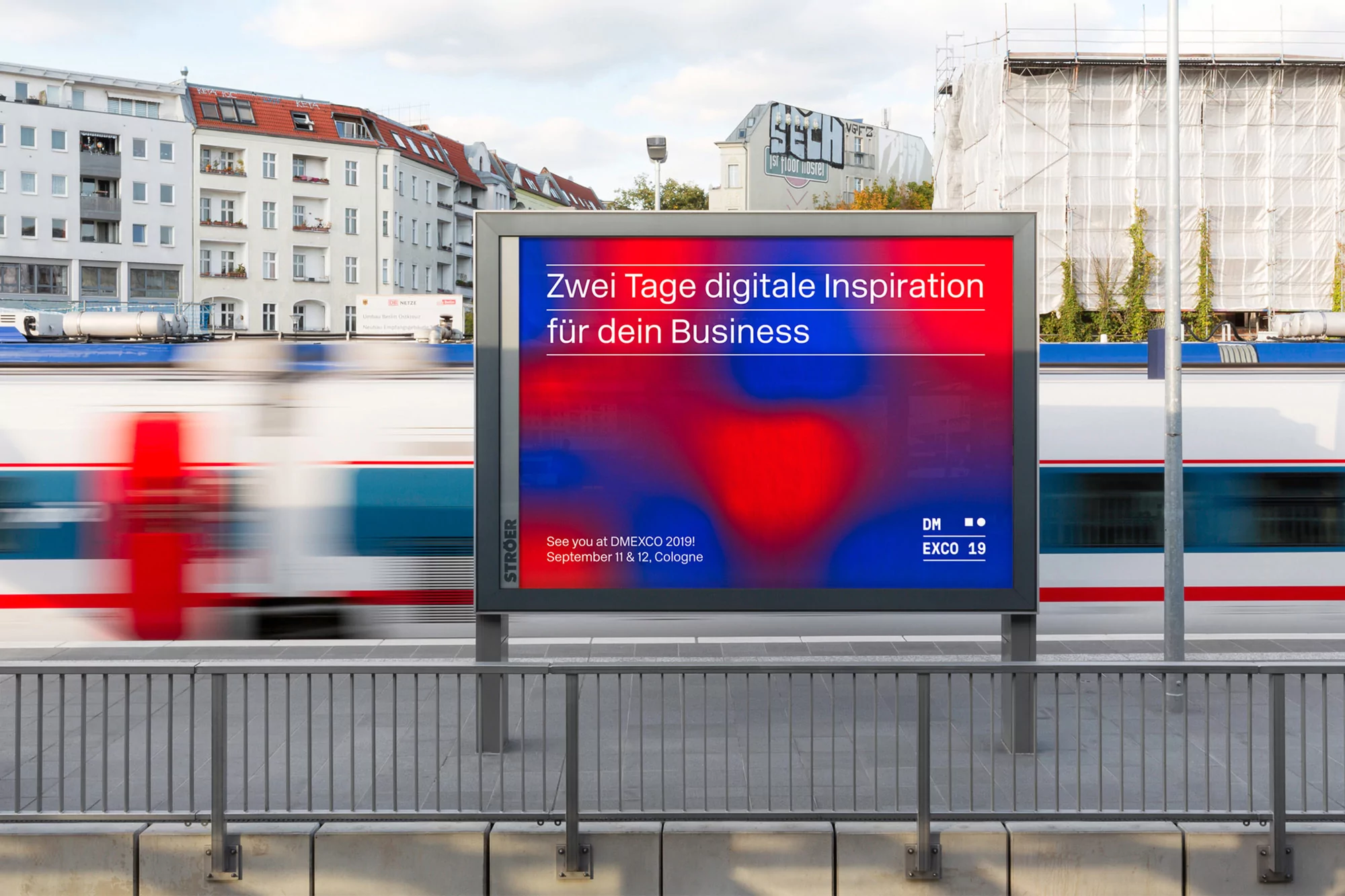 Outdoor billboard with digital advertising for DMEXCO 2019, promoting digital inspiration for business, next to a train track.