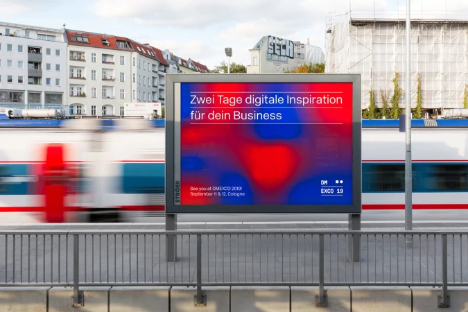 Outdoor billboard with digital advertising for DMEXCO 2019, promoting digital inspiration for business, next to a train track.