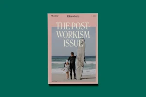 Magazine cover titled The Post-Workism Issue featuring a man in a wetsuit holding a surfboard with a child on a sandy beach.