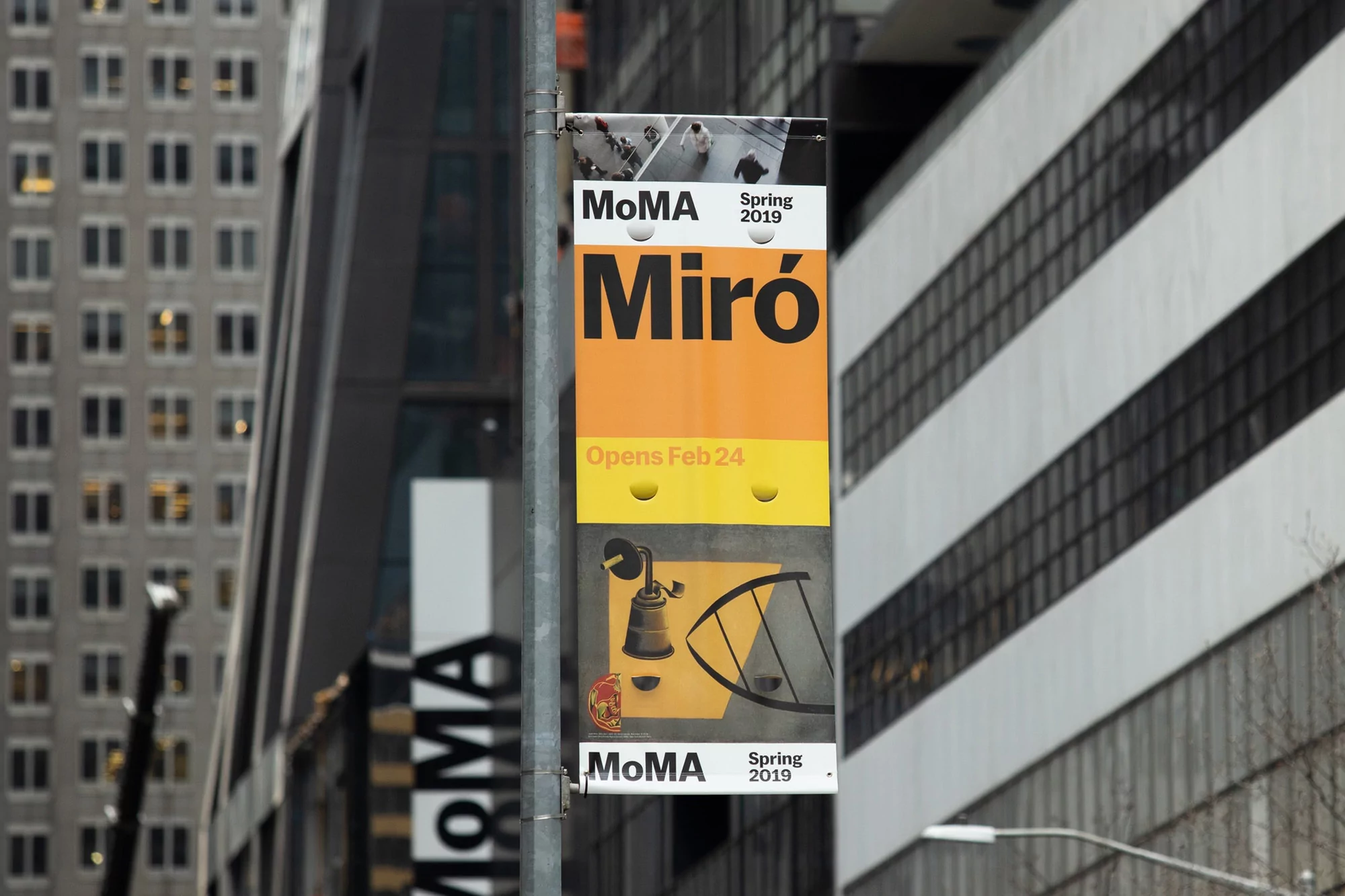 MoMA museum banner advertises the Miró exhibition for Spring 2019, with an opening date of February 24, outside a city building.