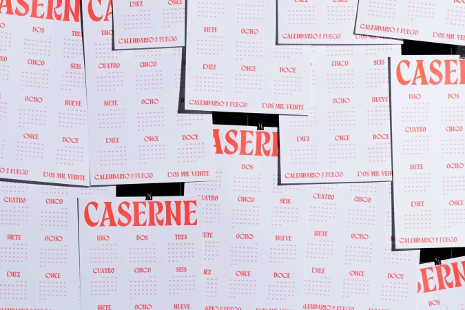 Overlapping Calendario Fuego 2020 promotional posters with red lettering and numbers, attached to a surface with black binder clips.