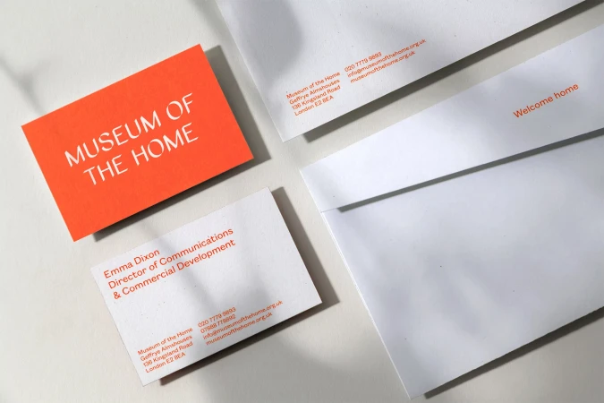 Museum of the Home stationery including envelopes and business cards on a white surface, angled close-up shot, clean aesthetic.