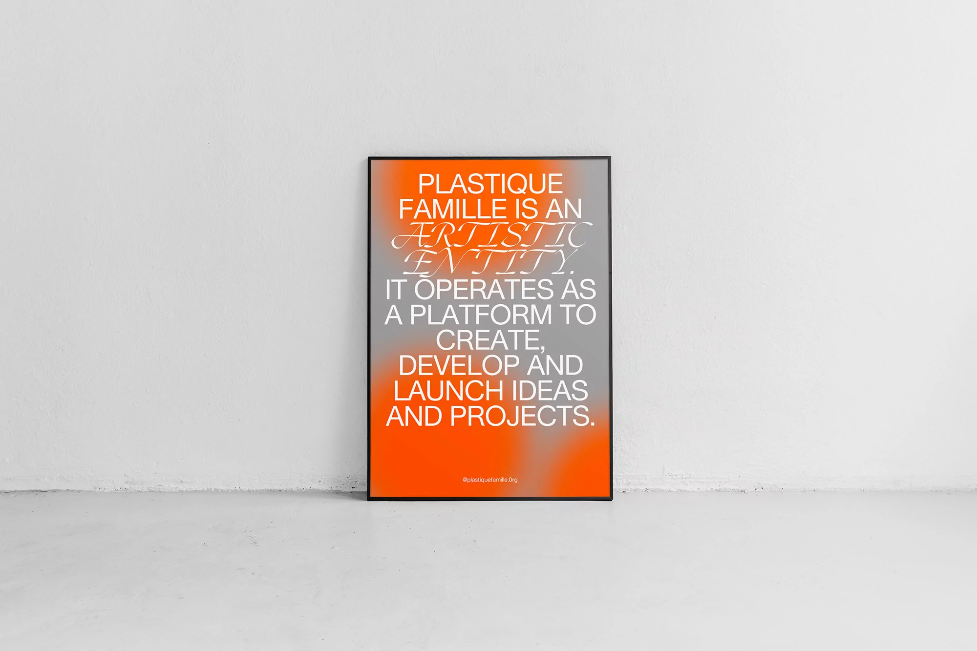 Framed poster featuring stylized text in white and orange tones, displayed against a plain white wall and floor.