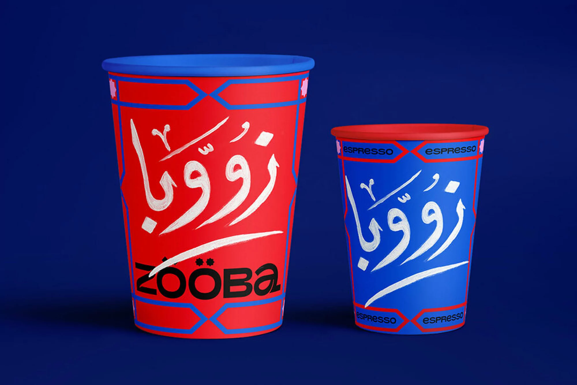 Two colorful paper cups are angled against a blue backdrop, featuring vibrant red and blue hues, adorned with Arabic calligraphy.