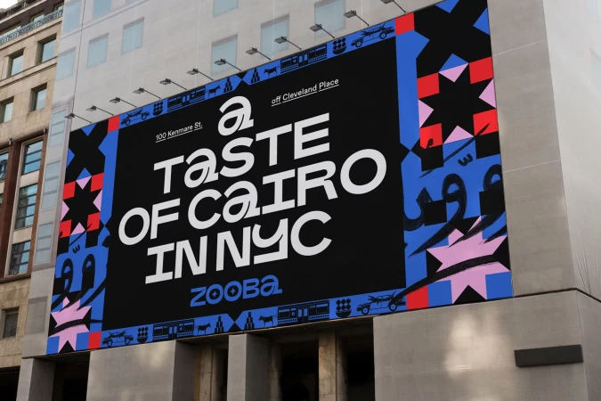 Large outdoor advertising billboard for Zooba restaurant featuring bold typography and geometric patterns on a building in an urban setting.