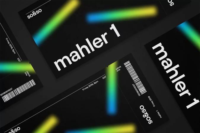 Close-up of concert tickets featuring the text 'mahler 1' with teal and yellow accents on a dark background.
