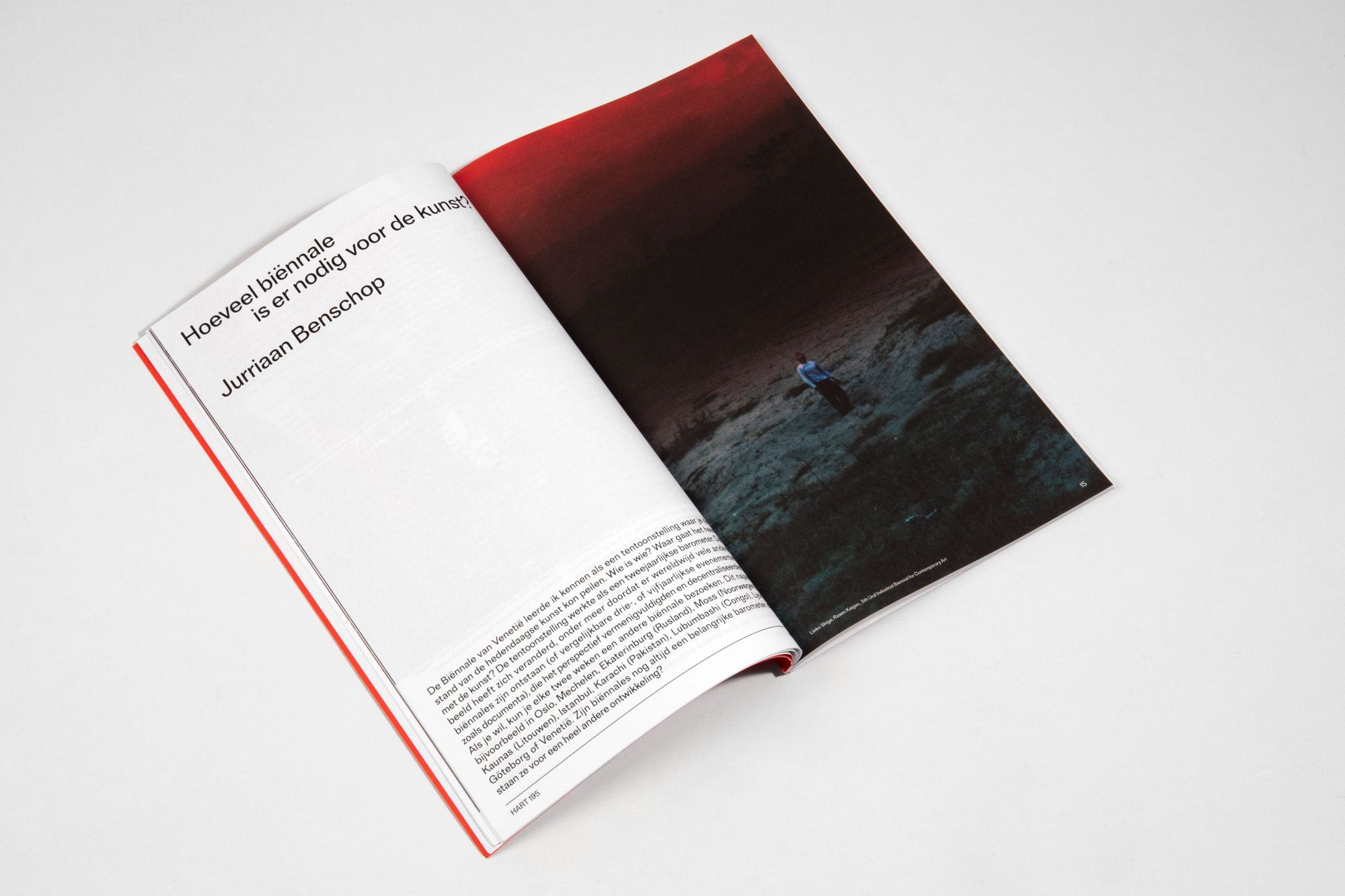 Open magazine features an image of a person standing on a dark, rocky landscape with a dramatic, red-toned sky. Text is visible on the opposite page.