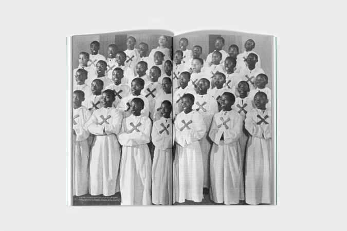 Black and white photograph of a large children's choir in white robes singing indoors, captured in a magazine spread.