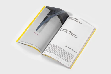 Open magazine spread featuring bold typography and minimalist layout against a white background