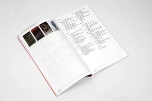 Open magazine spread showing printed article pages with tabular layout and small thumbnail images on a plain white surface