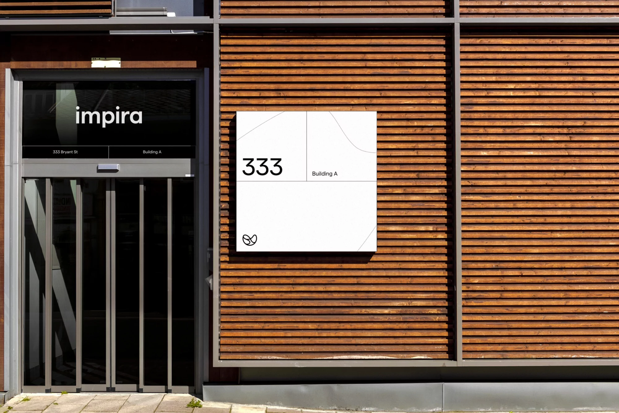 Exterior view of a modern office building with natural wood siding and signage indicating the address, promoting a sleek, professional image.