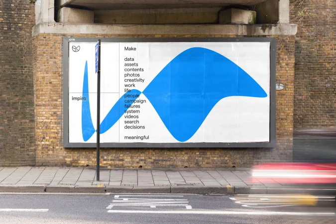 Outdoor billboard featuring white background with blue graphic design, and marketing text, mounted on a brick wall along a city street.