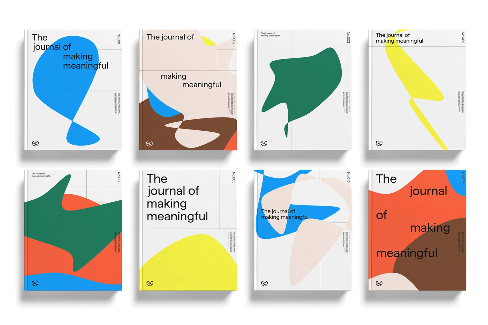 Eight 'The Journal of Making Meaningful' magazines. Each features unique abstract shapes in hues of blue, green, orange, yellow, and brown.