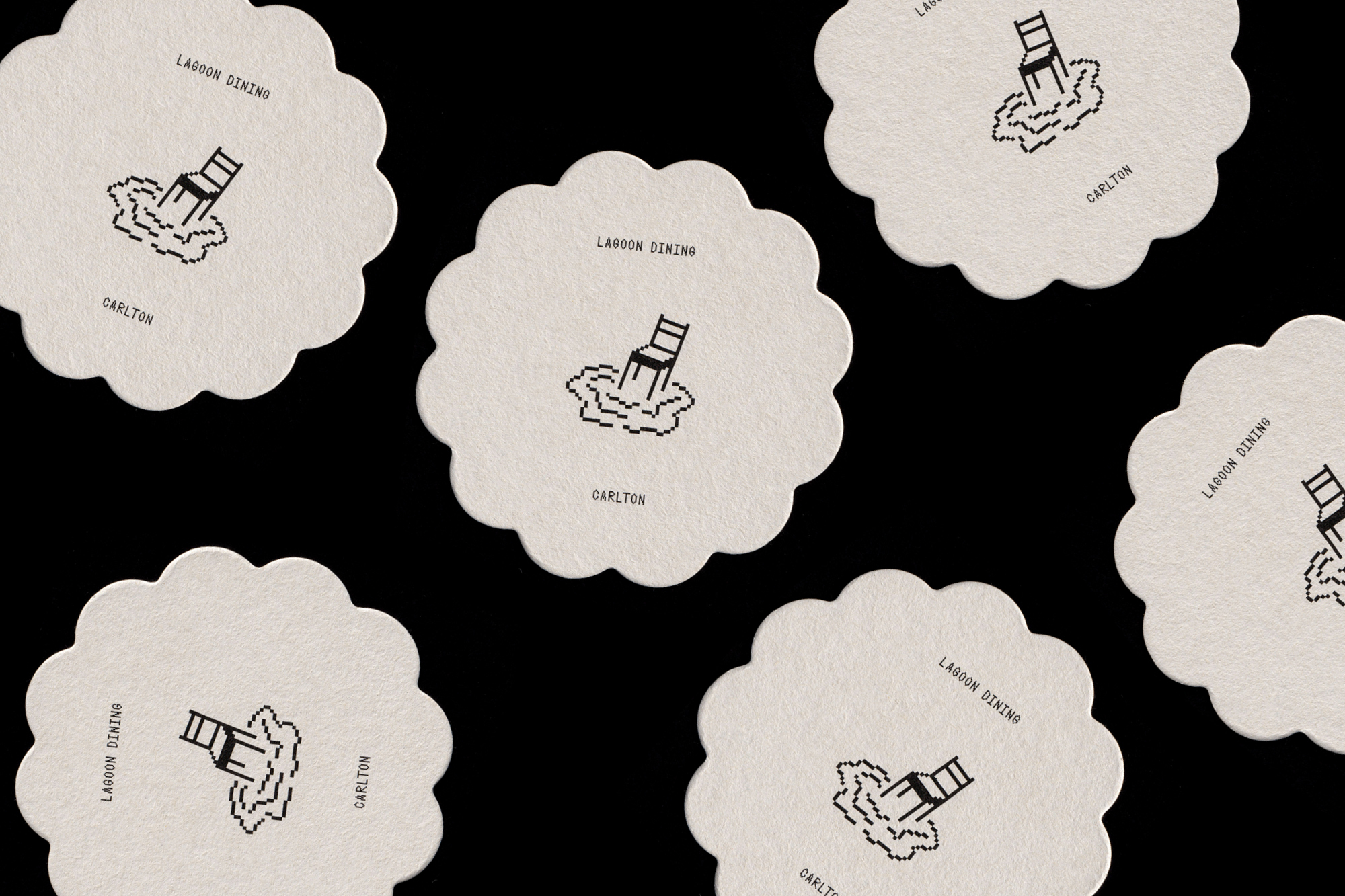 Stylized coasters featuring chair illustrations in water with 'Lagoon Dining' and 'Carlton' text, arranged on a dark background.