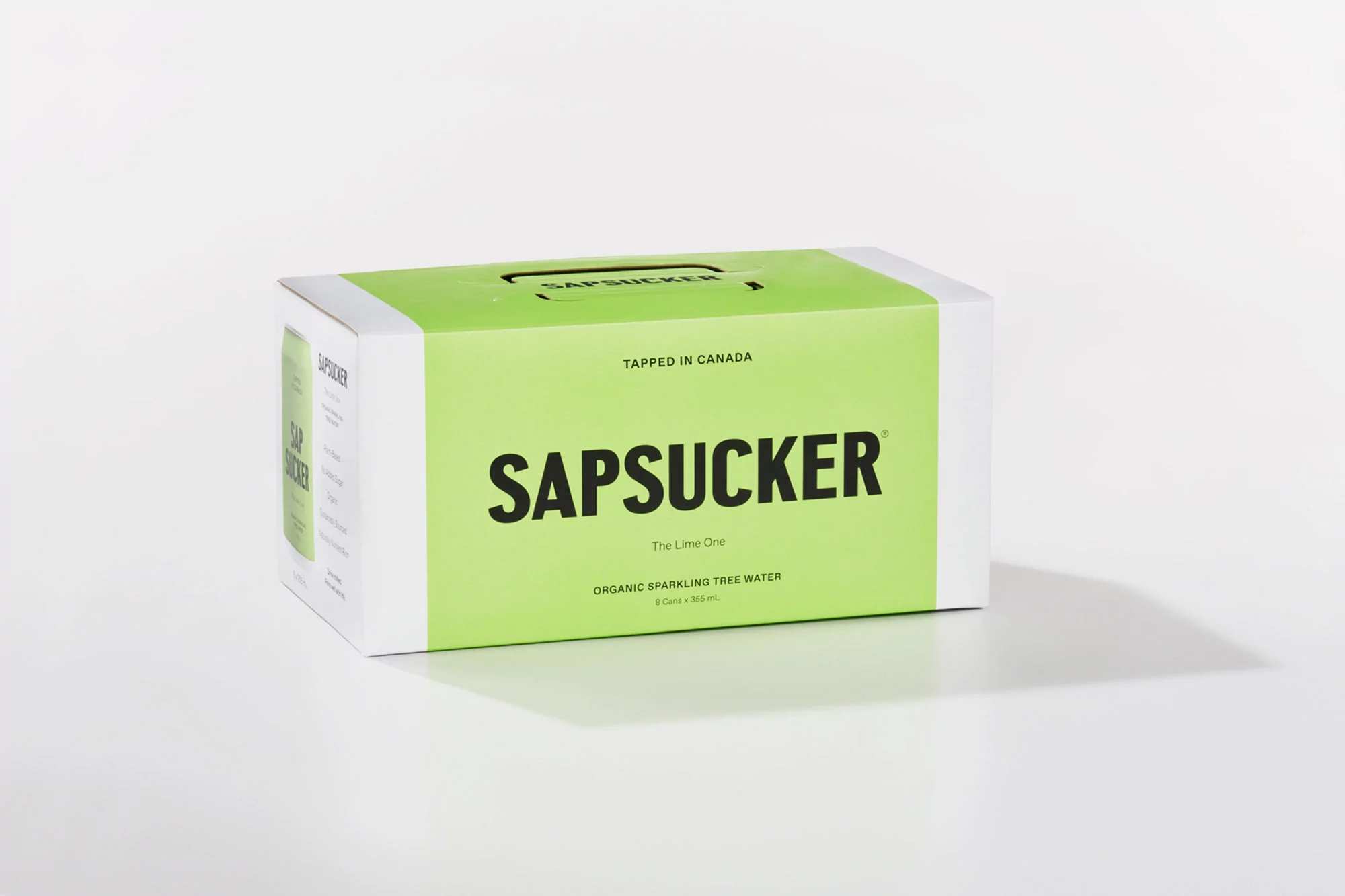 Sapsucker brand sparkling tree water in a carton on a white surface, product shot, minimalist presentation, white background.