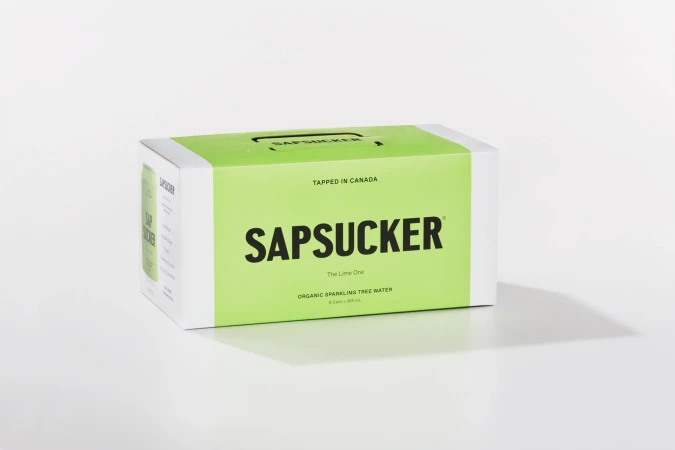 Sapsucker brand sparkling tree water in a carton on a white surface, product shot, minimalist presentation, white background.