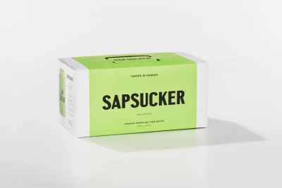 Sapsucker sparkling tree water packaging box featuring a bright green and white design against a seamless background