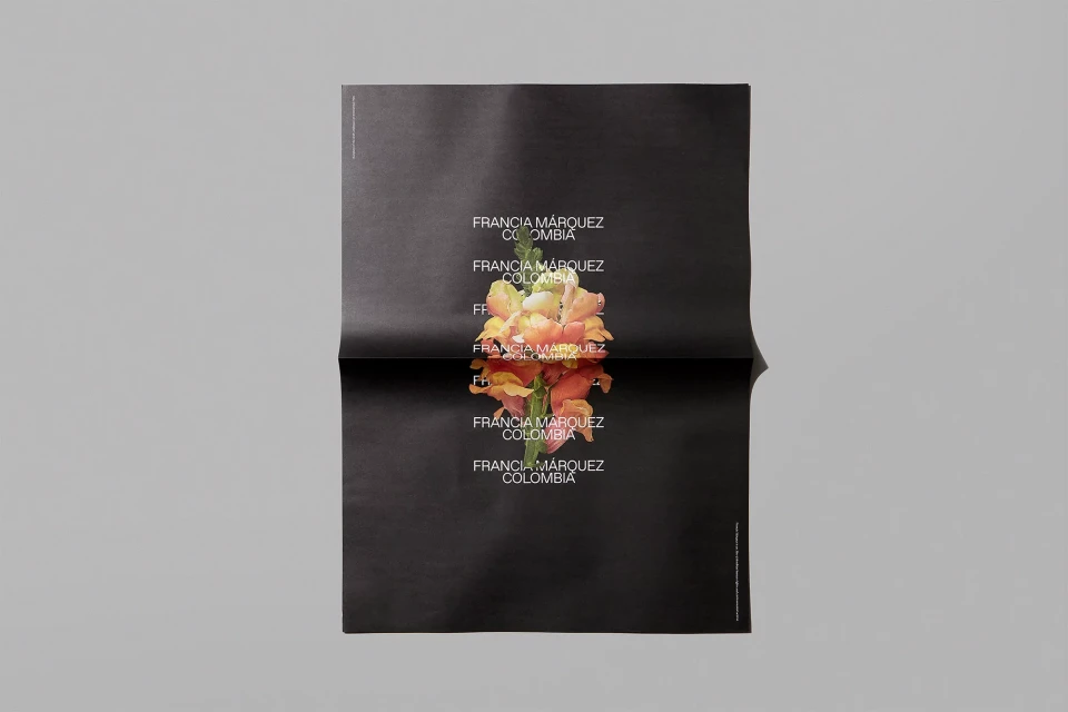Black poster featuring stacked text 'Francia Marquez Colombia' around a central floral image, set against a neutral gray background.