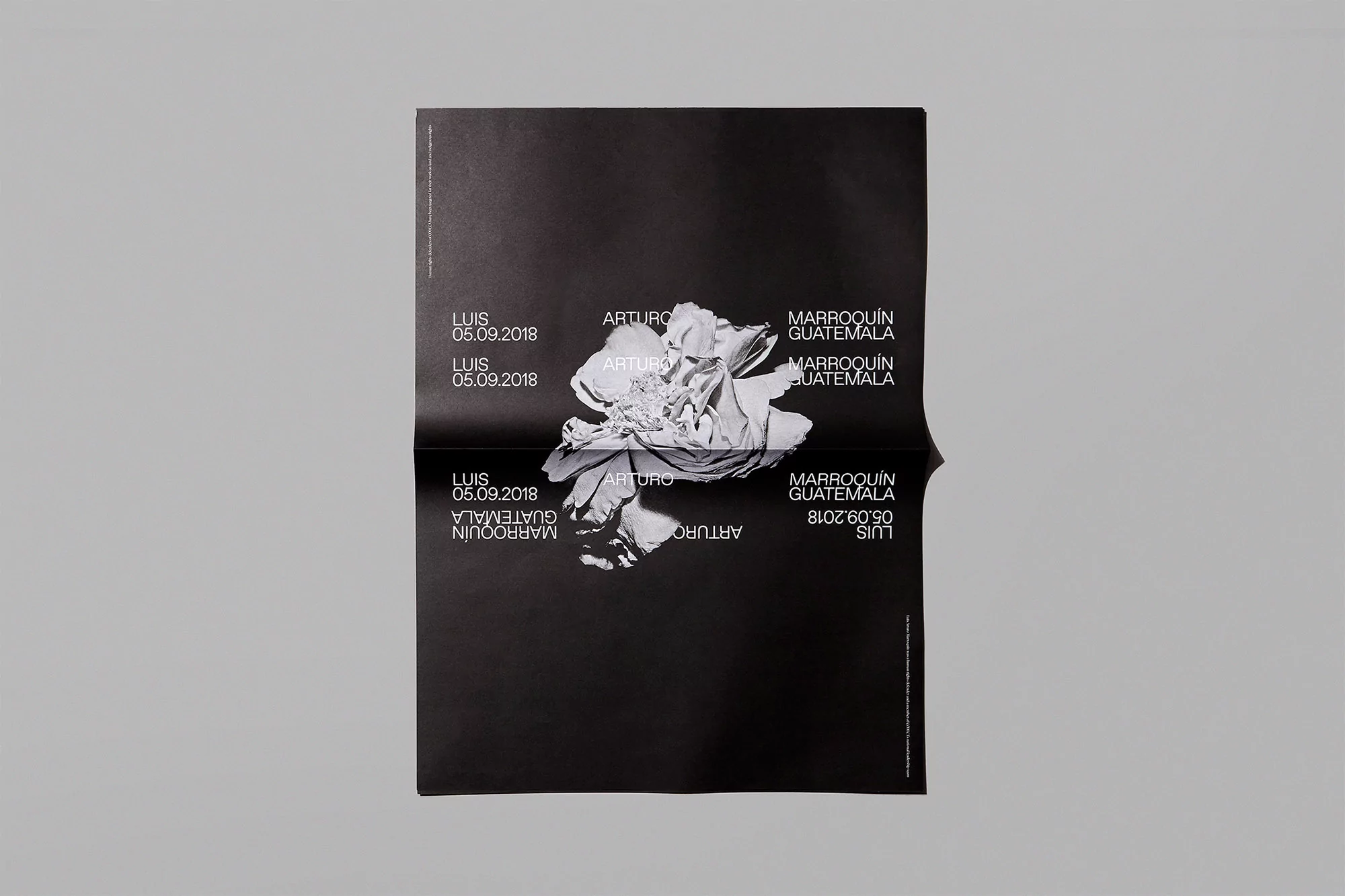 Folded black poster featuring an abstract floral image and text including names like ARTURO and LUIS, plus location GUATEMALA and date 05.09.2018.