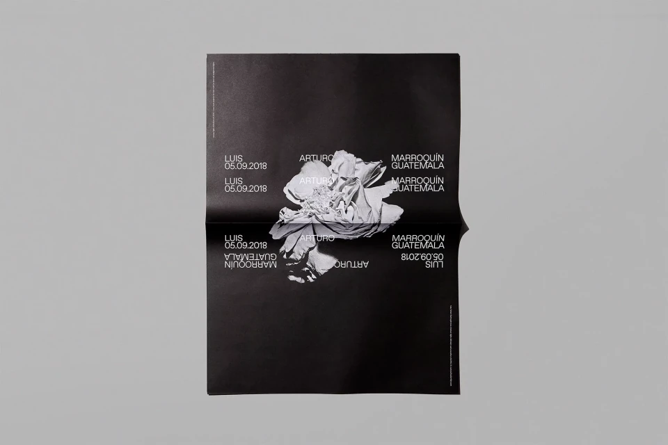 Folded black poster featuring an abstract floral image and text including names like ARTURO and LUIS, plus location GUATEMALA and date 05.09.2018.