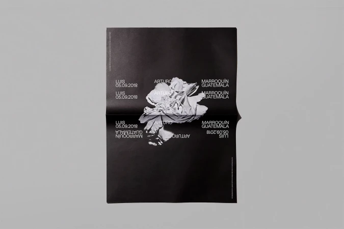 Folded black poster featuring an abstract floral image and text including names like ARTURO and LUIS, plus location GUATEMALA and date 05.09.2018.