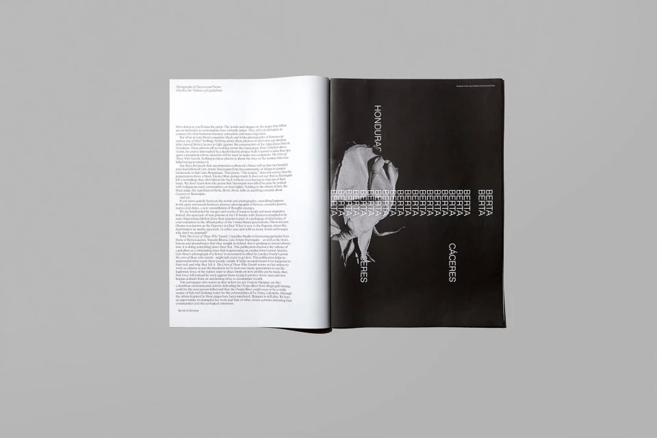 Open magazine with a striking black and white image of a flower next to text-filled pages, spread against a neutral gray background.