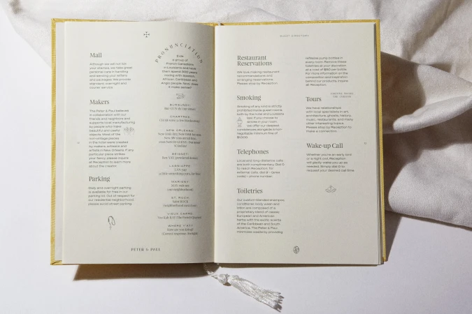 Open guest directory on a white surface with information about the hotel's amenities such as dining, tours and concierge services.